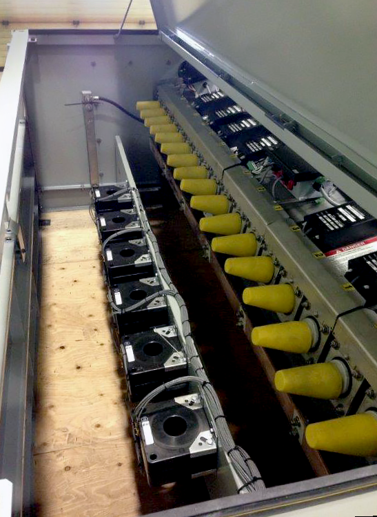 Se observa el interior de una unidad del Interruptor de Distribución Subterránea Vista® de Supervisión Remota. La parte superior de la unidad está abierta. A la derecha, las boquillas están cubiertos por tapas amarillas. Abajo a la izquierda, seis vías yacen a nivel del "piso".