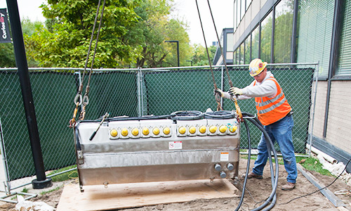 two men with hard hats  installing cable to a Vista pad mount unit